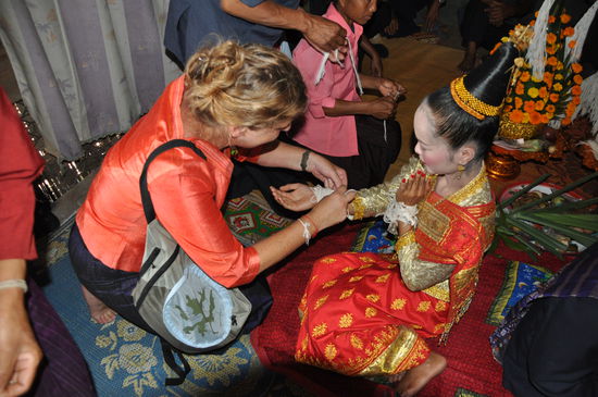 Cotton-Bänder mit guten Wünschen und Geldscheinen werden dem Brautpaar um die Armgelenke gebunden