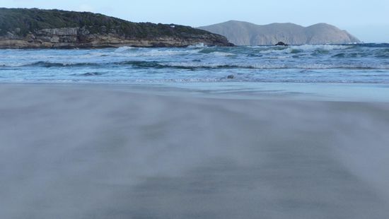 Wind..recht oft und oft recht stark. Das verschwommene ist Sand der uber die Kueste geblasen wird.