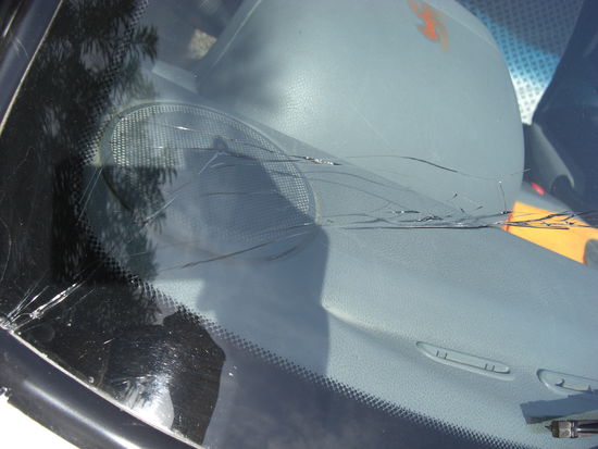 kaputte Windschutzscheibe unseres Autos - das Hakenkreuz, ein hinduistisches Glückssymbol, auf dem Armaturenbrett