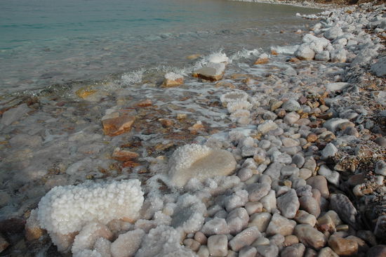 die Steine am Ufer sind von einer dicken Salzkruste überzogen