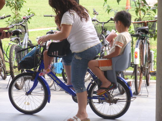 Eine Mutter faehrt ihre Kinder spazieren...