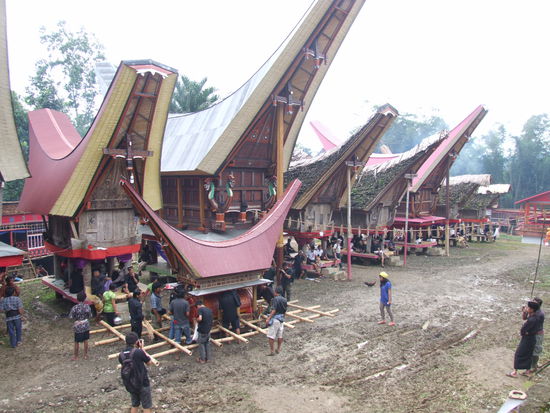 Dorfkulisse - die Trauergäste machten es such unter den Reisspeichern bequem. Im Vordergrund ist das temporäre Haus mit dem Sarg des Verstorbenen