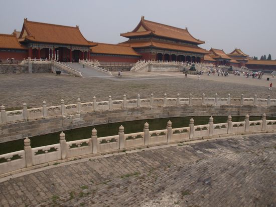 Die Verbotene Stadt stellt ein Meisterwerk der chinesischen Architektur dar. Ihre Anlage entsprach der Weltsicht der kaiserlichen Herrscher: ein annaehernd schachbrettartiger Grundriss – ausgerichtet an der Nord-Sued-Achse – und die Verbotene Stadt als Machtsymbol des Kaisers in der Mitte. Die Daecher waren teilweise vergoldet und alle mit in Gelb, der Symbolfarbe des chinesischen Kaisers, glasierten Ziegeln gedeckt. Kein Gebaeude in Peking durfte die Verbotene Stadt in der Hoehe ueberragen. Der gesamte Baukomplex hat eine Grundflaeche von 720.000m² und eine bebaute Flaeche von 150.000m². Auf dem Gelaende befinden sich 890 Palaeste mit unzaehligen Pavillons mit 9.999 1/2 Raeumen. Der halbe Raum hat symbolischen Charakter. Nach der Legende durfte nur der Himmel einen Palast mit 10.000 Raeumen besitzen, daher mussten sich die „Soehne des Himmels“ mit 9.999 1/2 zufrieden geben. Geschnitzte Marmorbalustraden und glasierte Dachziegel zeugen von hohem kunsthandwerklichen Standard. Die Mauer der Verbotenen Stadt ist 10 Meter hoch und 3.428 Meter lang sowie von einem 3.800 Meter langen, 52 Meter breiten und 6 Meter tiefen mit Wasser gefuellten Graben umgeben.