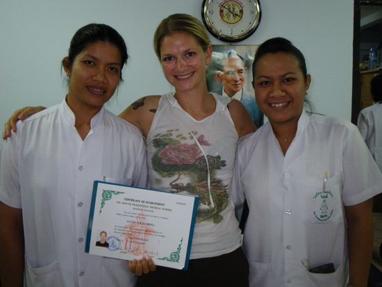 Stolze Absolventin mit Lehrerinnen vorm Bild des Koenigs.