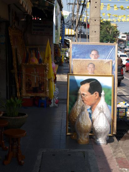 Es gibt in ganz Bangkok hunderte von Geschaeften die nichts anderes als Bilder des Koenigs und weitere Fanartikel rund um die koenigliche Familie verkaufen. Im Augenblick haben sie sehr viel zu tun, da der Koenig am 5. Dezember Geburtstag hat. Zu diesem Anlass kaufen viele Thais neue Bilder, mit denen sie Ihre Wohnungen und Geschaefte dekorieren und Fahnen, die sie bei den Paraden zum Geburtstag schwenken.