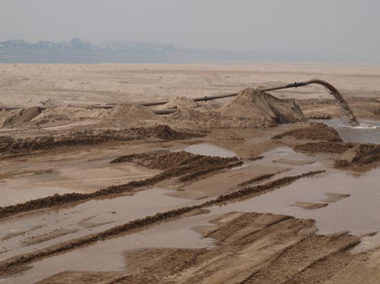 Blick auf den Mekong.  Leider von der eigentlichen Uferpromenade nur schwer zu erkennen. Eine Baustelle und fehlendes Wasser sorgen dafuer. Zum Glueck haben wir nicht extra fuer ein Zimmer mit Flussblick gezahlt.