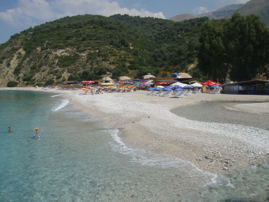 Ein typisches Bild: ein Bilderbuchstrand und im Hintergrund die Bunker aus Enver Hoxhas Zeiten