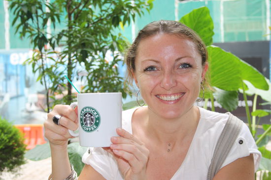 Happy mit der Starbucks-Tasse in der Hand 