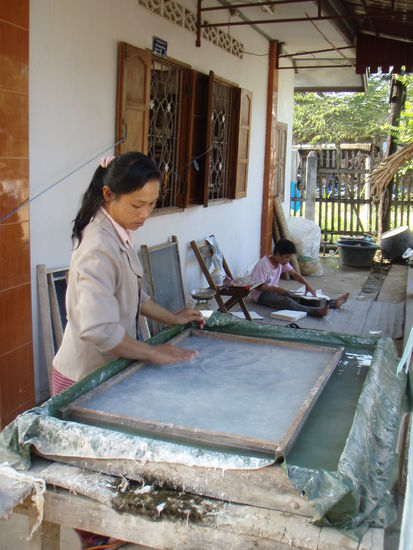 so wird papier gemacht. Der Bursch im Hintergrund faltet schon die Briefumschlaege.