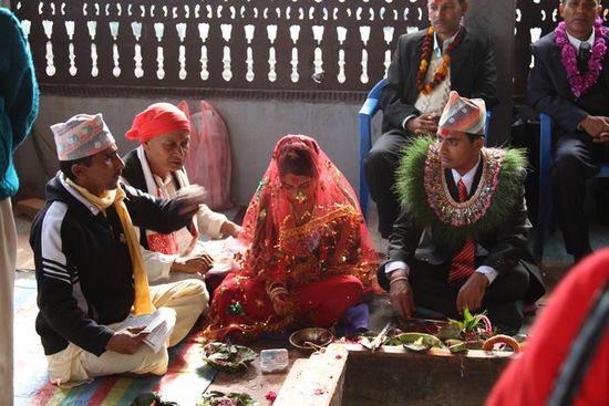 Hier sehen wir eine nepalesische Hochzeit.
In Nepal sind Zwangshochzeiten der Alltag. Die Eltern entscheiden ueber die Kinder. Links ist der Priester- keine besondere Kleidung!