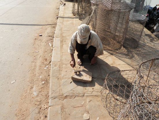 Das gleiche, er klopft die einzelnen Draehte vom ehemaligen Maschendrahtzaun wieder gerade. Muehsam !!