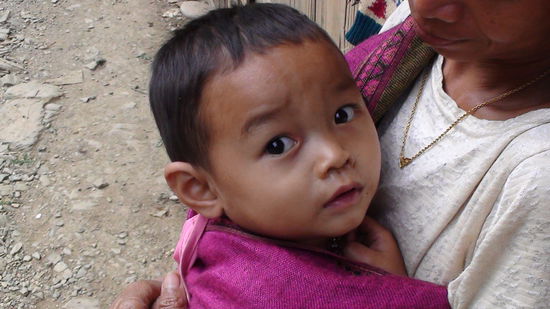 Das Kind einer Verkaeuferin beim Wasserfall