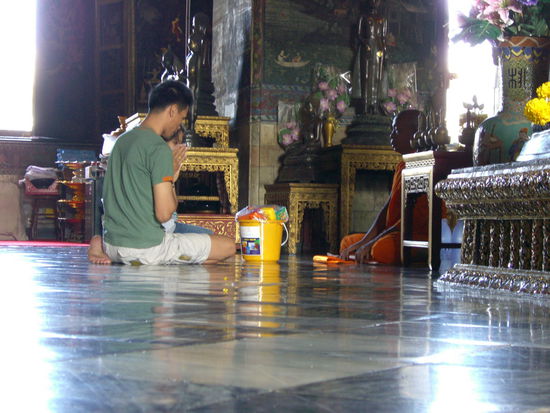 Ein Mönch nimmt die Spenden von einem Gläubigen entgegen