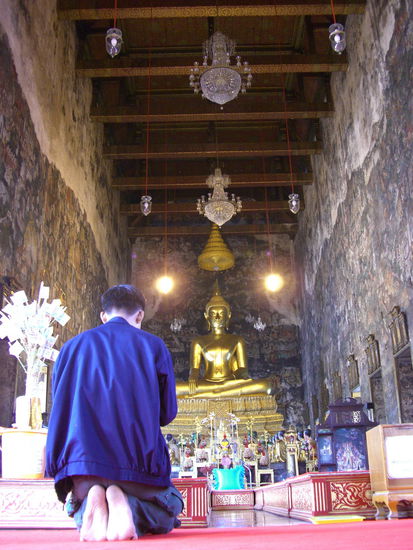 Tempelbesucher vor Buddha Phra Puttha Tri Lokachetmit beim Gebet