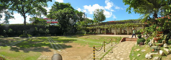 Der Innenhof, nun von der Nordseite ausgesehen. Im Hintergrund ist das Hafengebäude zu erkennen. Einen Gärtner huscht noch eben durch das Bild um die Bewässerung anzuschließen.
