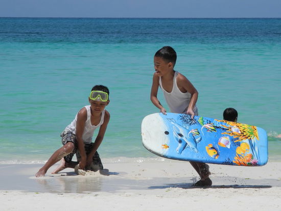 Obwohl es kaum Wellen, auf denen man surfen könnte gibt, sind bunte bemalte Bretter im Einsatz.