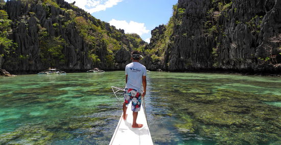 Der Bootsmann am Bug über dem Korallenriff.