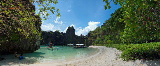 Pause am Hidden Beach. Ganz links im Bild sitzt unser 80-jähriges Geburtstagskind mit einem Tourguide im Schatten. Obwohl drei Boote in der Lagune ankern, ist der Strand fast leer. Fast alle planschen im warmen Wasser.