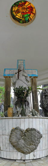 Der Matniloc Shrine mit Herz, Kreuz und Christusfigur. Die Kuppel mit dem Buntglasfenster schützt vor dem Regen.