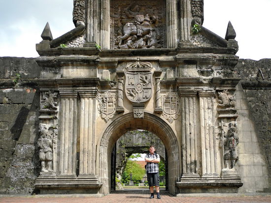 Georg steht lässig im reich verzierten Eingangstor.