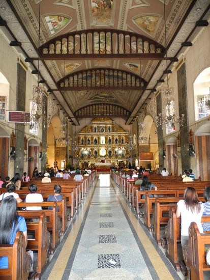Gläubige beten andächtig im Hauptschiff der Basilika.