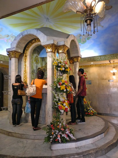 Am Schrein von Santo Niño beten einige Besucher.