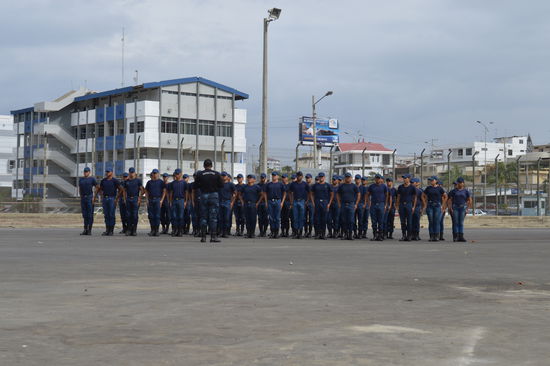 Ausbildung der Polizei, fotografieren streng verboten, nach Auskundschaften der Lage, geheimes Foto durch den Maschendrahtzaun geschossen. Der Insructor an die 190 cm, befiehlt, es wird ganz laut gesungen, am Schluss verstehe ich einige male: Ecuador, Ecuador, 
viel Glück wünsche ich. Siehe ganz rechts: auch weibliche sind dabei
