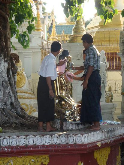 Angestellte beim polieren einer Buddhastatue...