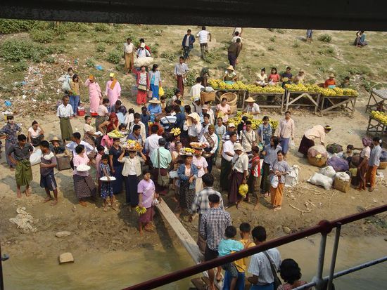 Diverse Verkaeufer mit Waren in Koerben auf ihren Koepfen warteten um das Boot zu betreten...