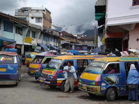 Coole Lokal-Buesse in allen Farben... und im Hintergrund verdeckt von den Wolken, der Gunung Sibayak. (Vulkan)