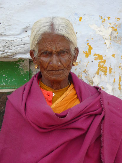 Alte Frau in einem Dorf. Die einfachen Leute schauen immer sehr ernst in die Kamera, wie bei uns vor 100 Jahren 