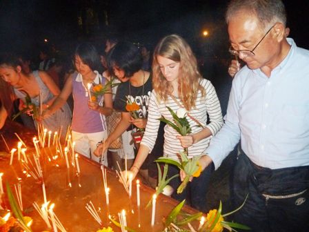 Nach den drei Rundgängen, werden die Räucherstäbchen, Kerzen und Blumen in vorbereitete Behälter mit Sand und Wasser gesteckt