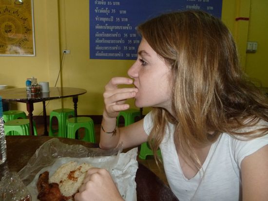 Zuerst nimmt man etwas Klebereis, drückt diesen in die gerösteten Zwiebeln und dann rein in den Mund!