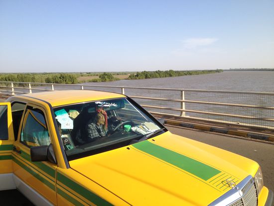 Mit diesem Taxi sind wir nun zu dritt während 2 Tagen unterwegs.
Erste Überquerung von einem Seitenarm des Gambia Rivers