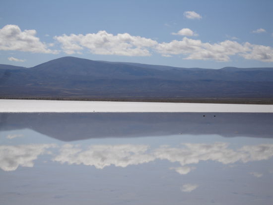 Wenige mm Regenwasser liegen auf dem harten Salz und bilden einen einzigartigen Spiegel