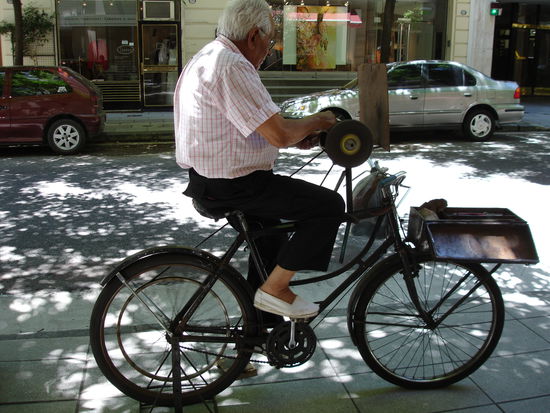 Der Messerschleifer bei der Arbeit (Fahrrad steht auf dem Trottoir)