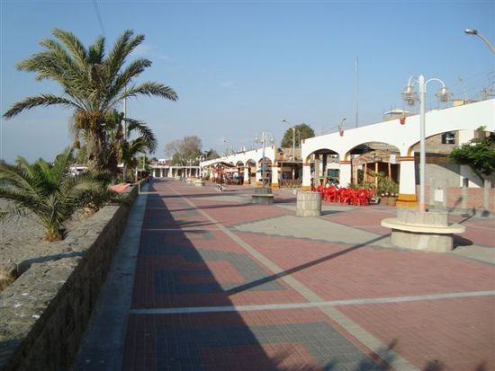 Uferpromenade von Paracas. Die weissen Bogen verdecken die Bauruinen und Holzhütten im Hintergrund.