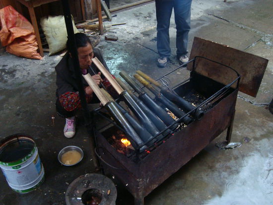 Das typische Dorf-Gericht: Reis in Babmusholz ueber dem offenen Feuer gebraten. Es ist immer wieder interessant, welche Techniken es gibt, die Glut auf der richtigen Temperatur zu halten 