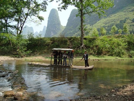 Auf dem Weg sollen wir einen Fluss ueberqueren, leider fehlt eine Bruecke. Zwei Bauern bieten den Transport fuer 1 Yuan pro Person an. Die umgerechnen 0.1 Euro sind zwar nicht viel, die Flussueberfahrt dauert aber auch nur knappe 10 Sekunden