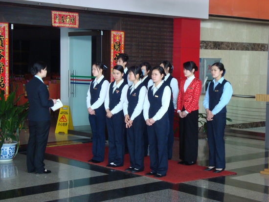 Am Morgen vor Arbeitsbeginn erhalten die Angestellen ihre Anweisungen vor dem Lokal. Bei der Aufstellung hat jeder seinen Platz (Koeche stehen immer hinten und tragen Mundschutz).