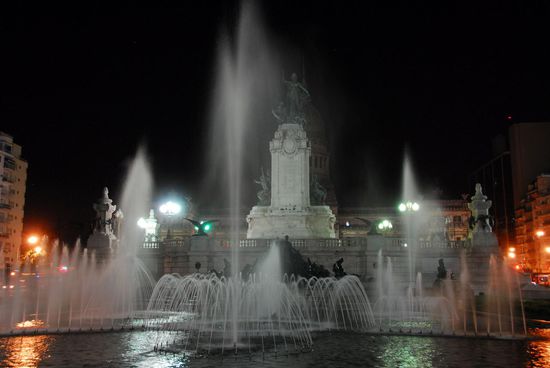 Der Springbrunnen und eines der vielen Denkmaeler der Stadt vor dem Kongressgebaeude.