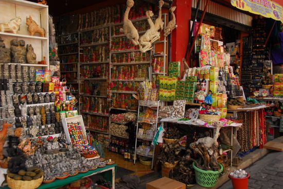 Dafuer hat die Stadt andere Dinge zu bieten, die man so auch nicht ueberall findet, so z. B. der so genannte Hexenmarkt. Zu den schraegsten Dingen, die hier verkauft werden, gehoeren fuer mich die getrockneten Lamafoeten als Gluecksbringer, die hier von der Decke haengen und in dem gruenen Korb stecken. Aber auch sonst gibt es allerlei Wunderliches. Und um die Ecke wird die Zukunft aus einer Handvoll Kokablaetter gelesen, die auf ein Tuch geworfen werden.