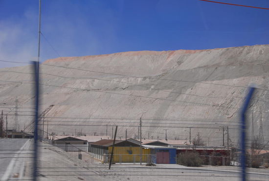 Verlassene Wohnhaeuser vor der Kulisse riesiger Abraumhalden