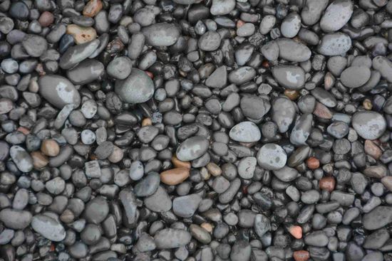 ...und wird vom der Gewalt der Brandung in einem endlosen Prozess zu kleinen, glatten Kieseln verarbeitet