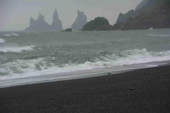 Die schwarzen Strände, die Felsformationen und die Höhlen aus Basaltgestein sind eigentlich eine Wanderung wert - aber bei Windstärke 8 und Nieselregen wird der Ausflug an die Küste sehr kurz