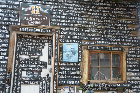 Die Aussenwaende seine Werstatt zieren Abschnitte von Motorradreifen, auf denen der Desert Doctor die Herkunft der Eigner geschrieben hat