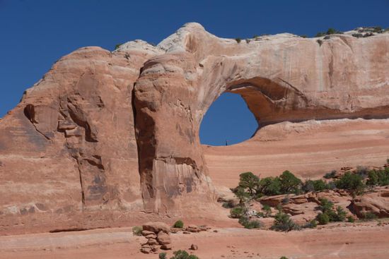 Der Arches Nationl Park kuendigt sich bereits auf dem Weg dort hin an: der Wilson Arch direkt am Highway