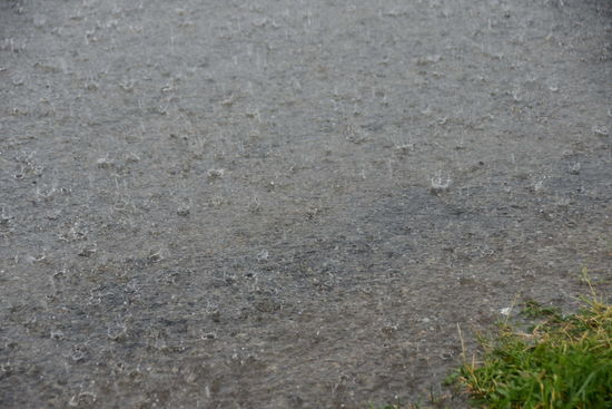 Geschützt in einer Bushaltestelle ziehe ich die Stulpen über Schuhe, als es so richtig anfängt zu gießen