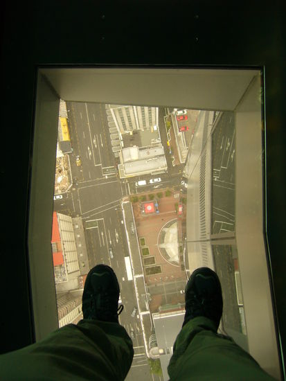 Aussicht vom Skytower durch die Glasplatte der Aussichtsplattform nach unten.