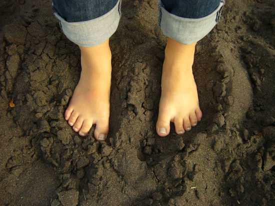 Kleine Fuesse im schwarzen Sand. Wem die wohl gehoeren???